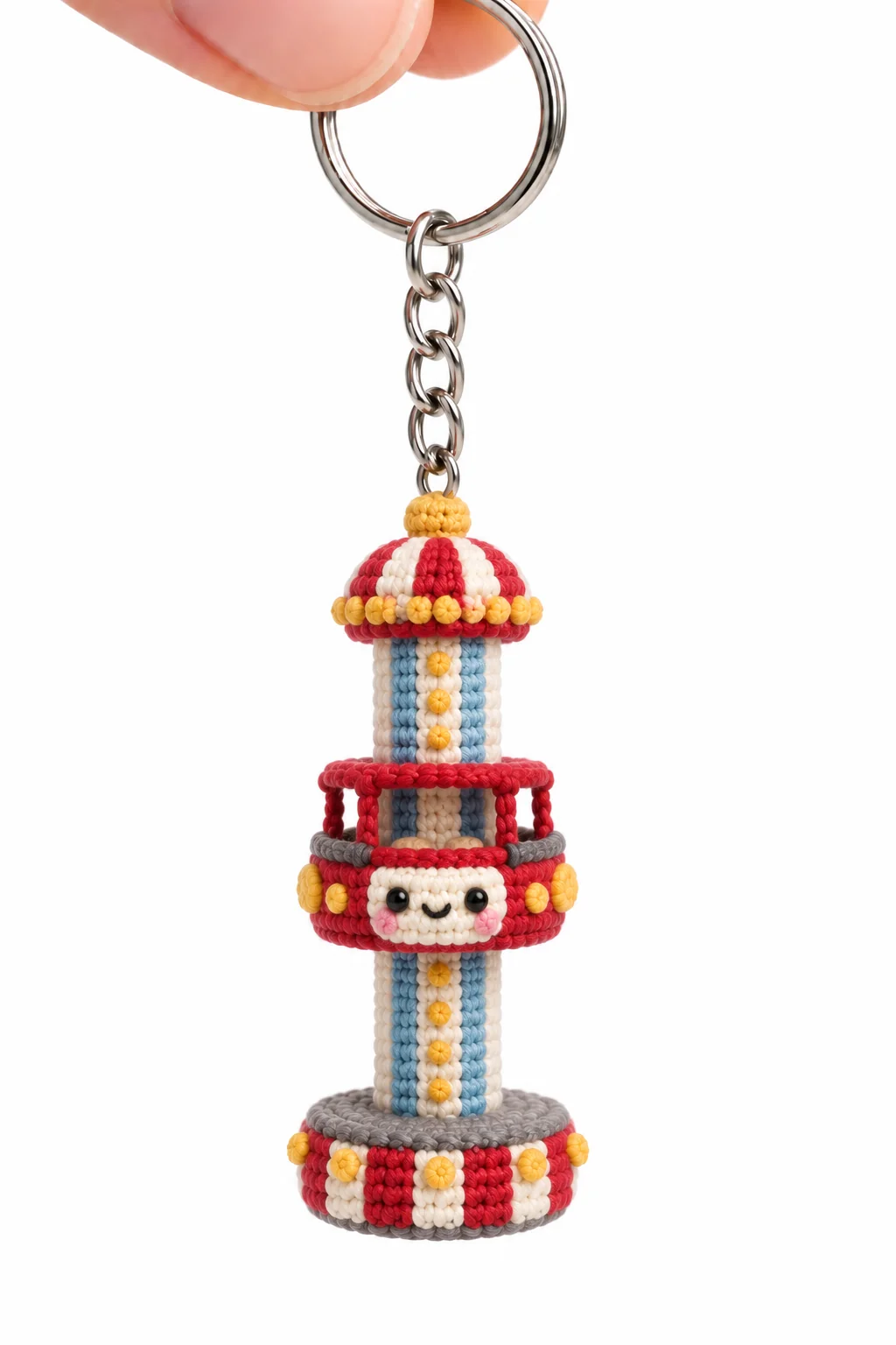 Crochet drop tower ride keychain with red and white striped canopy, blue striped column and a smiling red gondola ringed with yellow lights