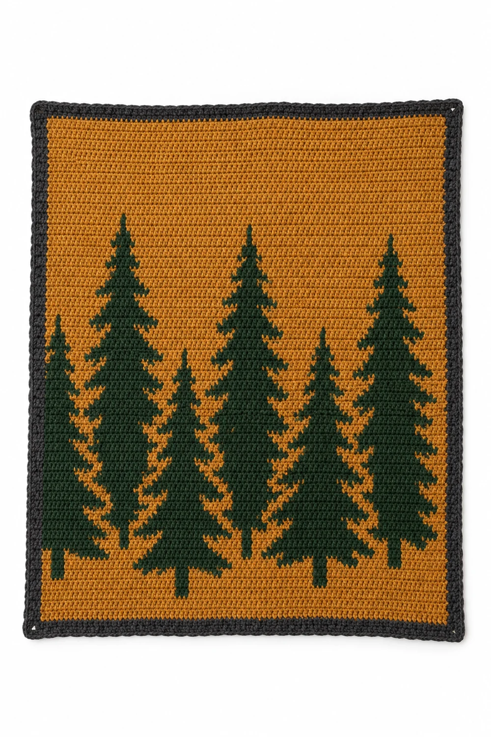 Crochet blanket with dark forest tree silhouettes over autumn colors