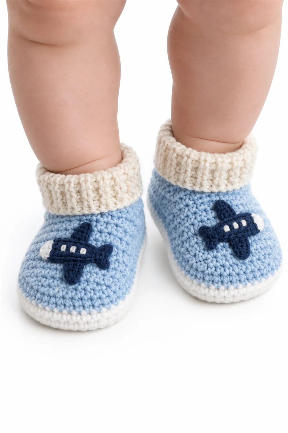 Blue crochet baby booties decorated with small airplane motifs