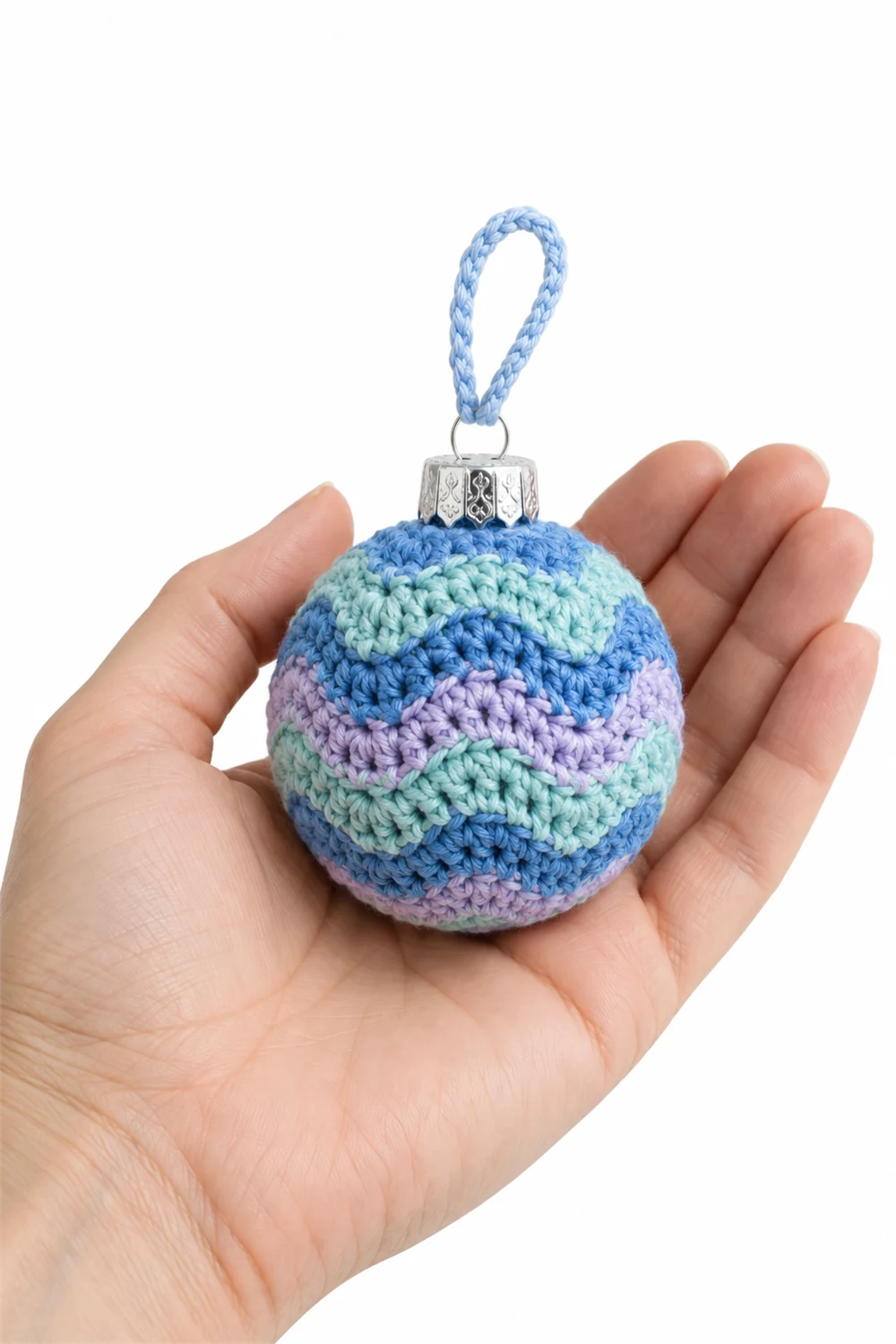 Blue and green crochet Christmas bauble with aurora swirl pattern