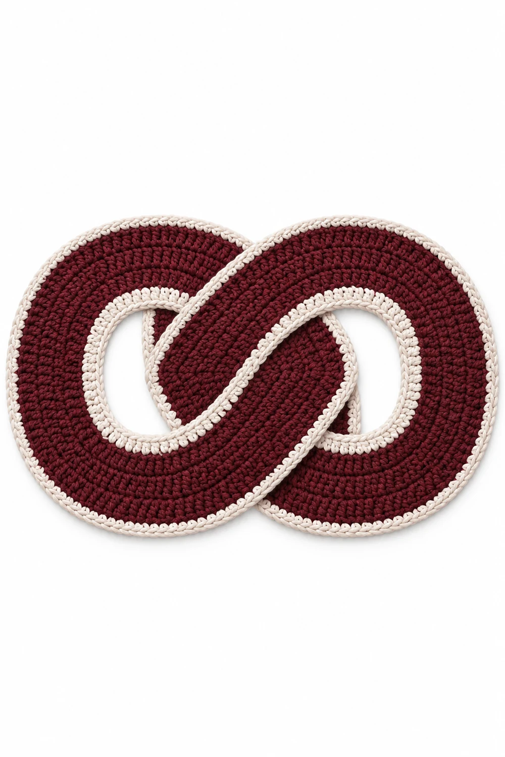 Burgundy crochet rug shaped as an infinity knot with interlaced sculptural loops