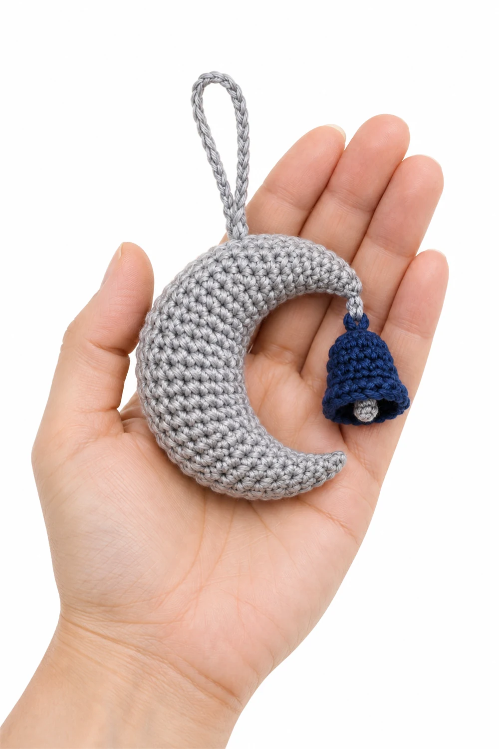 Silver crochet crescent moon ornament holding a tiny bell