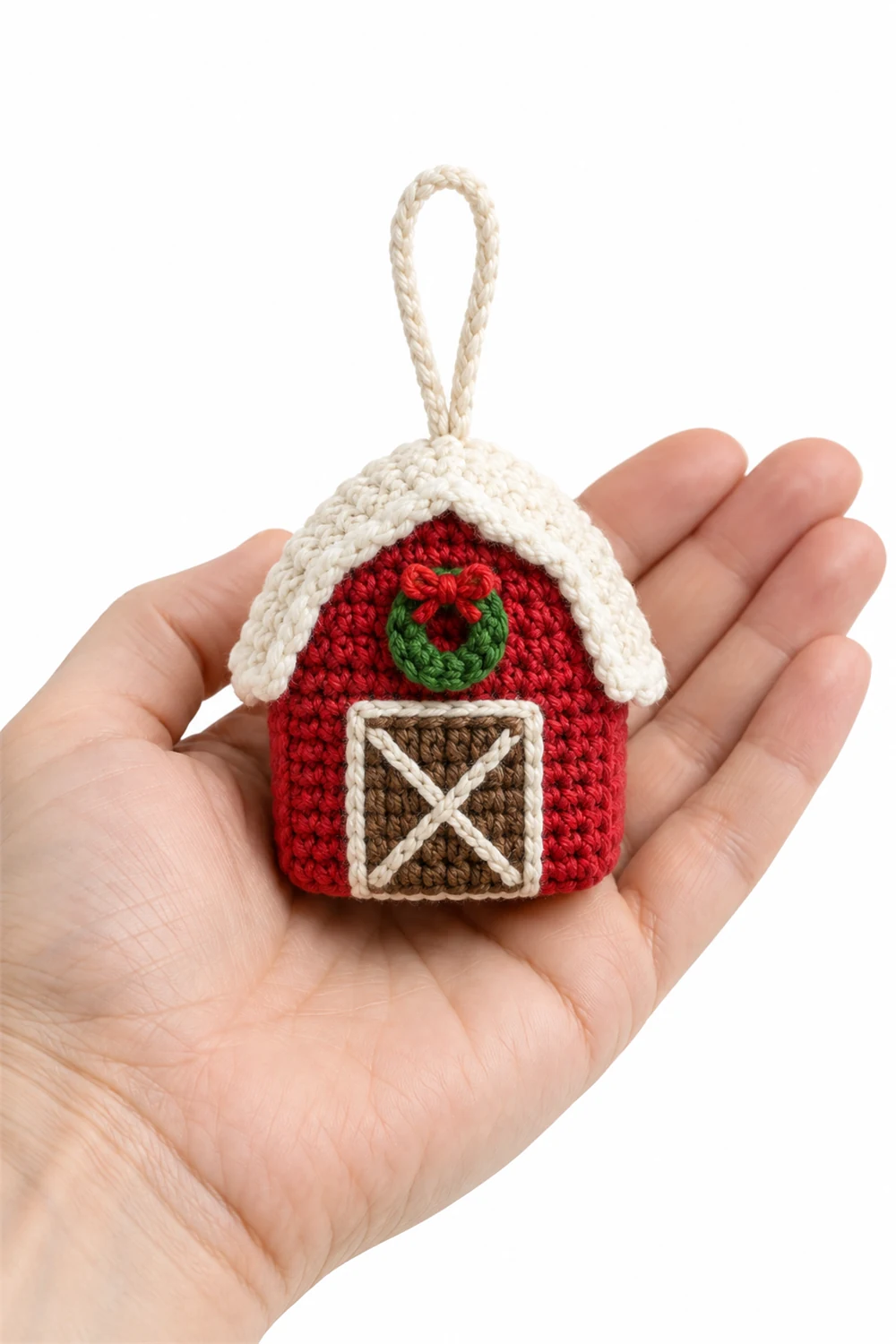 Red crochet barn ornament with white snow-covered roof