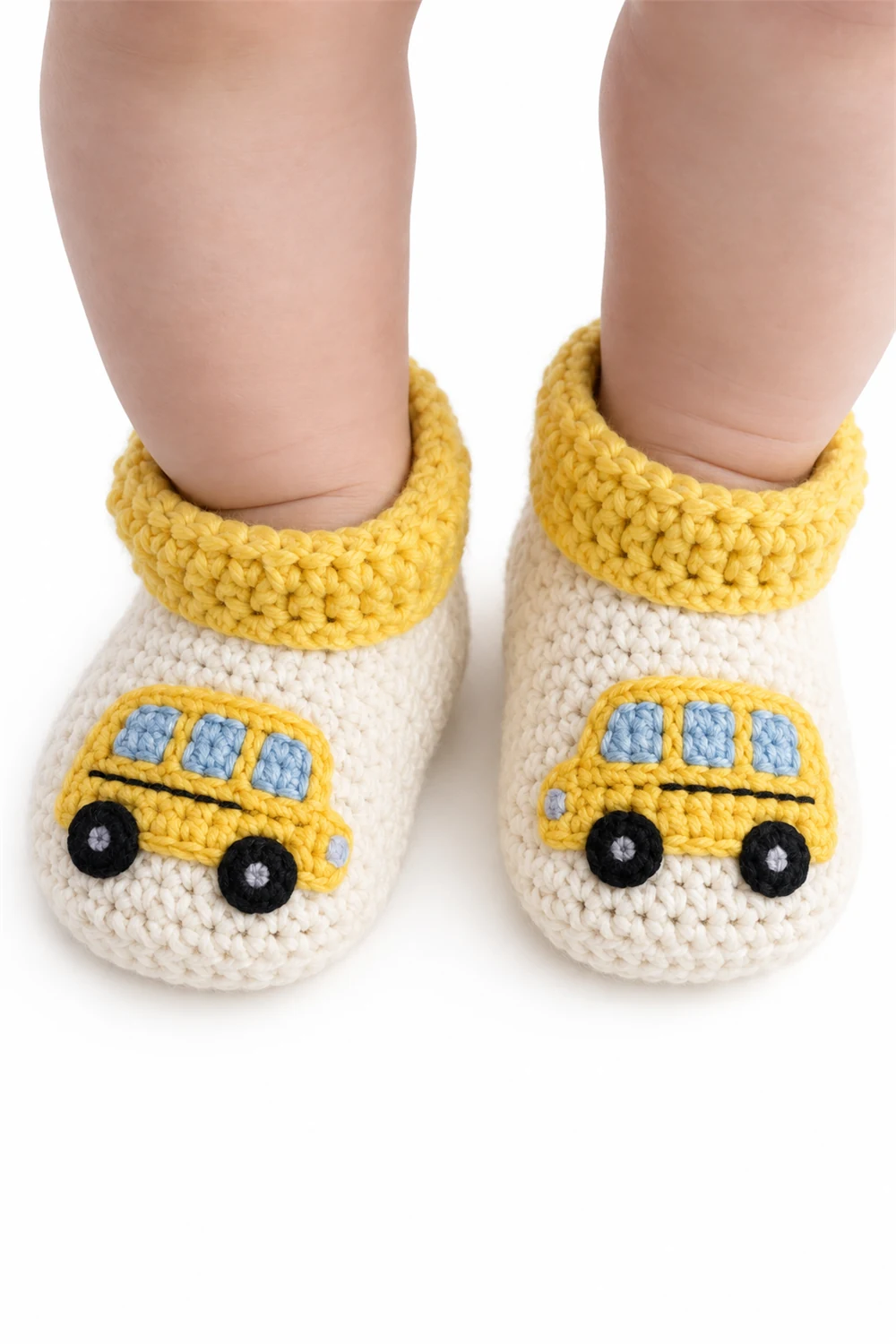 Yellow crochet baby booties with a cheerful bus motif